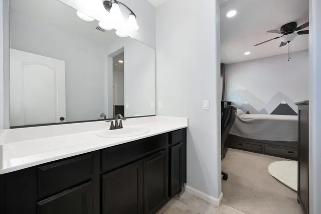 a en suite bathroom with a double vanity sink and a mirror