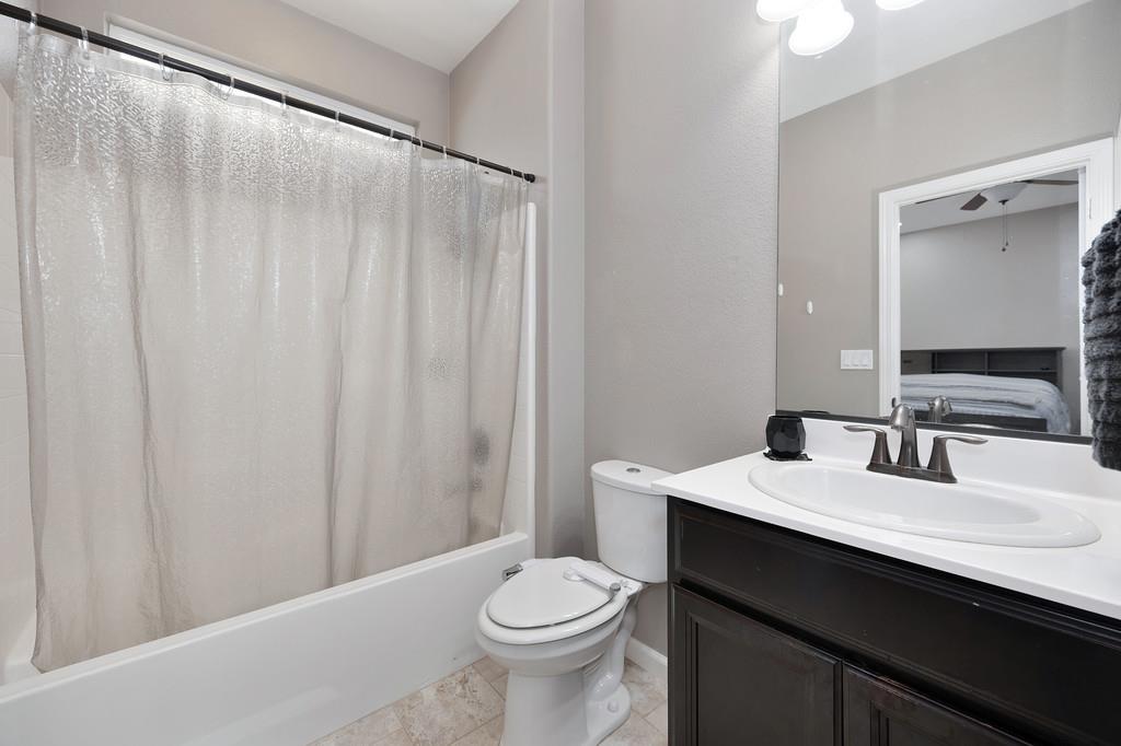 806 Mono Street Manteca, CA 95337 - Photo 22 of 38 a bathroom with a sink a toilet and shower curtain