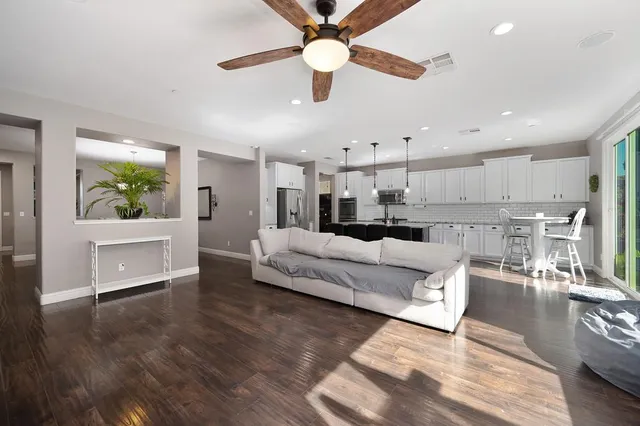 a living room with furniture and a wooden floor