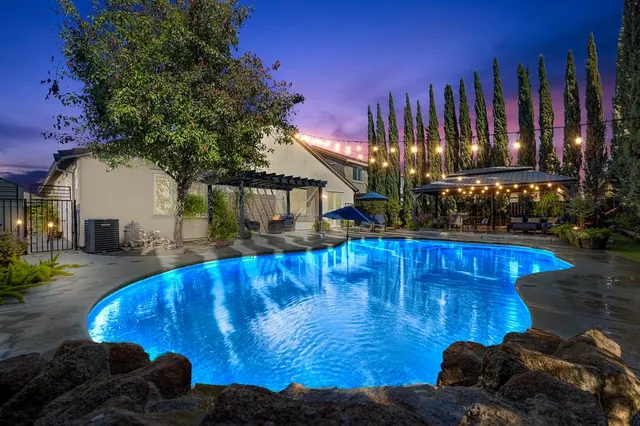 a view of a house with swimming pool and sitting area