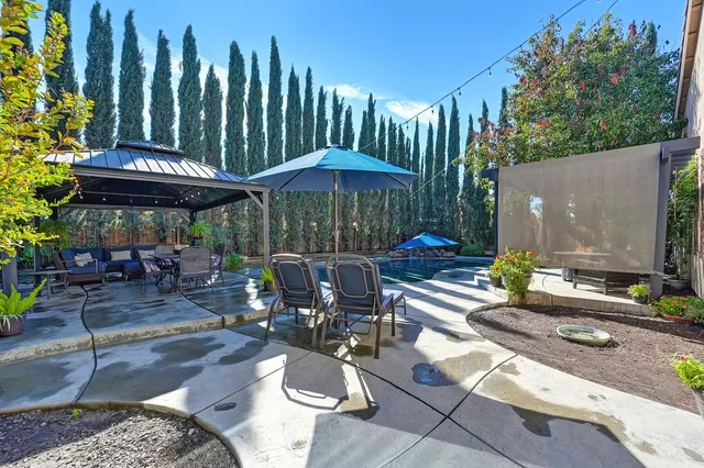 a view of a patio with table and chairs under an umbrella
