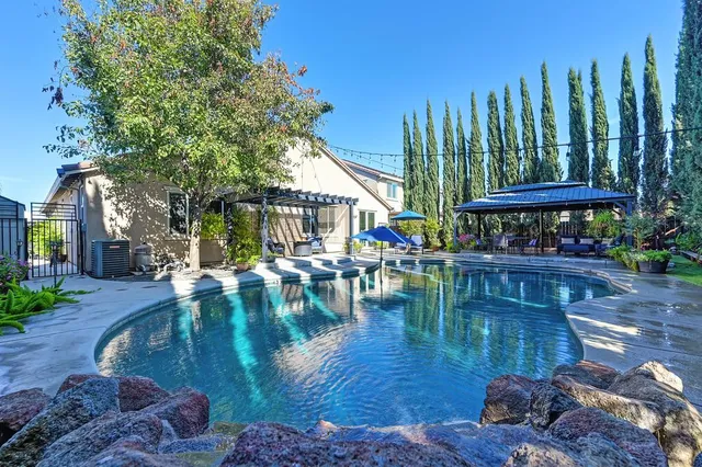 a swimming pool with outdoor seating and yard