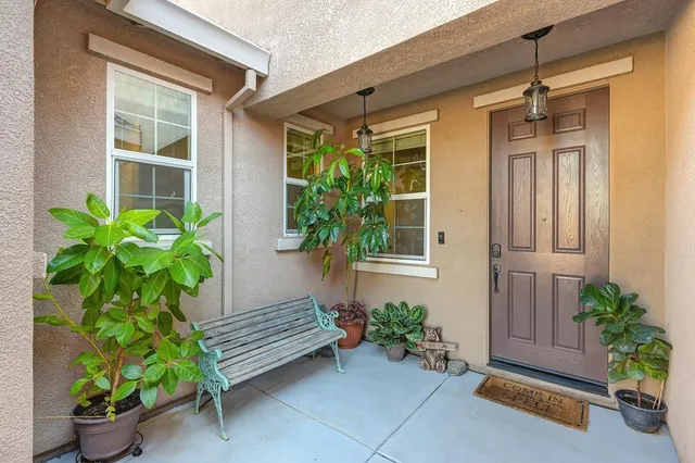 a front view of a house with potted plants