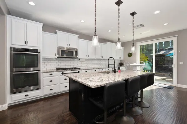 a view of a dining room with furniture a chandelier and wooden floor