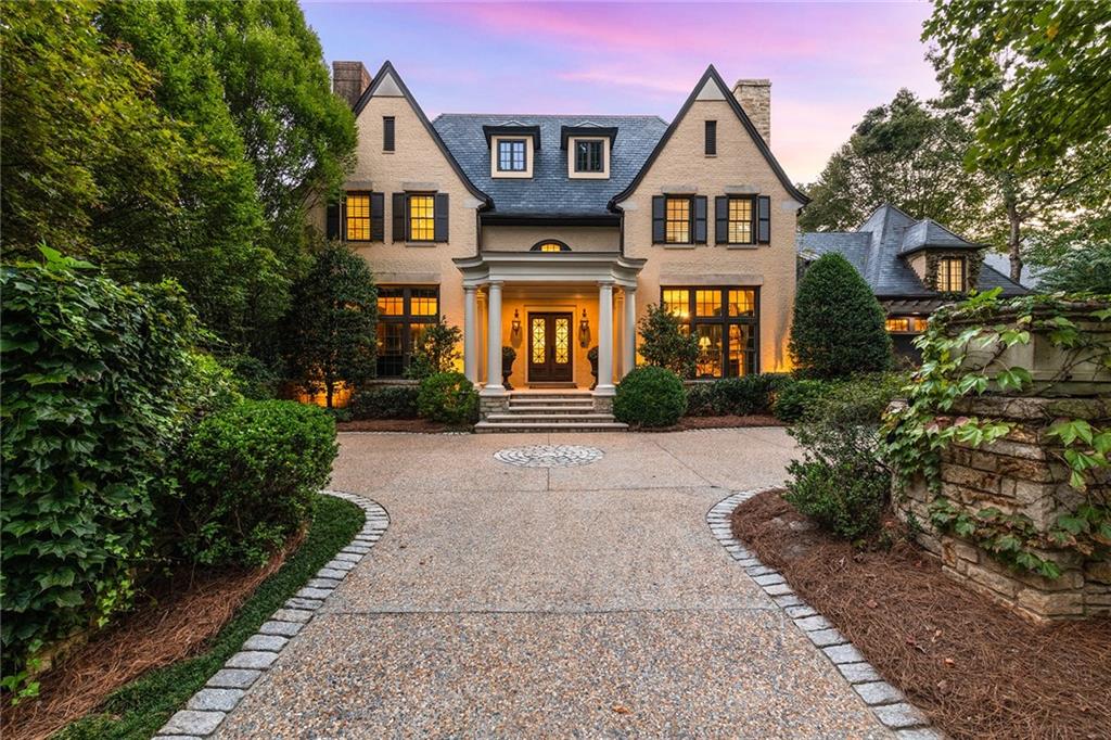 a front view of a house with a yard and trees