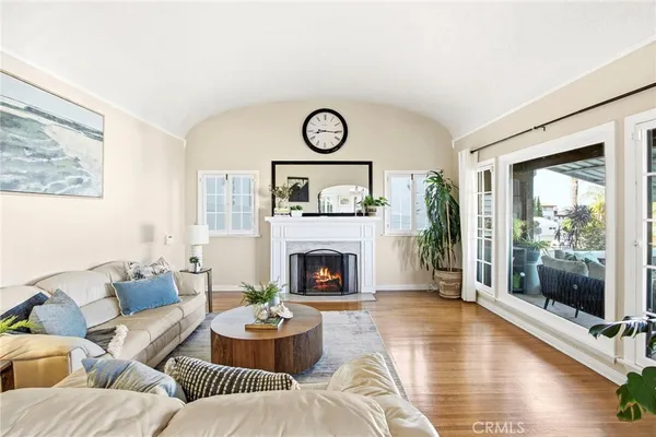 a living room with furniture a fireplace and a floor to ceiling window