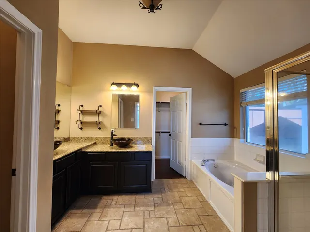 a bathroom with a tub sink and mirror