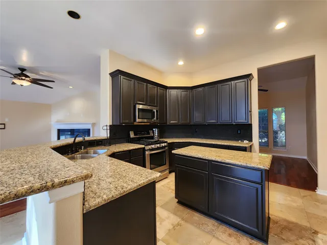 a kitchen with stainless steel appliances granite countertop a sink stove and refrigerator