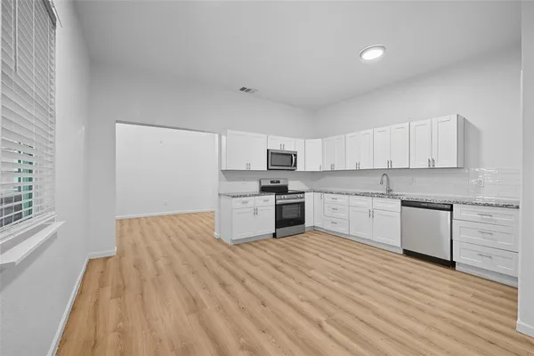 a large kitchen with a white wooden cabinets and white appliances