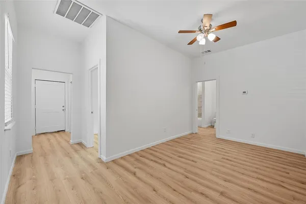 a view of a room with wooden floor and a ceiling fan