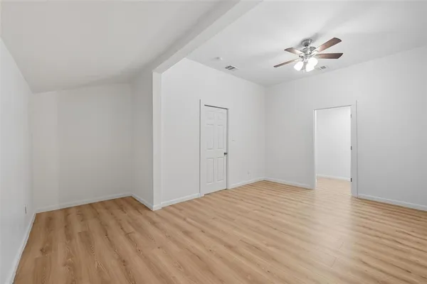 a view of empty room with wooden floor
