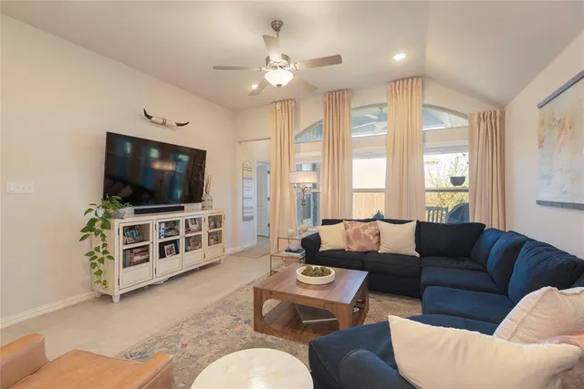 a living room with furniture kitchen view and a chandelier