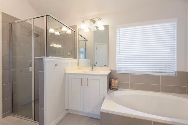 a bathroom with a bathtub a double vanity sink and a mirror
