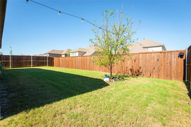 a view of a backyard with table and chairs and wooden fence