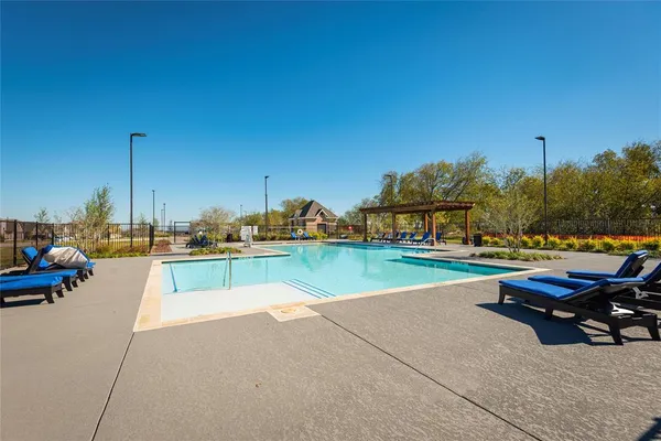 a park view with a table and chairs under an umbrella