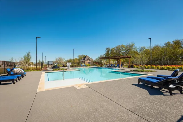 a park view with a table and chairs under an umbrella