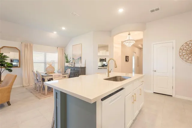 a kitchen with kitchen island granite countertop a sink counter top space appliances and cabinets
