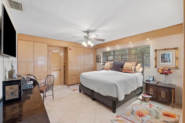 a spacious bedroom with a large bed and a chandelier