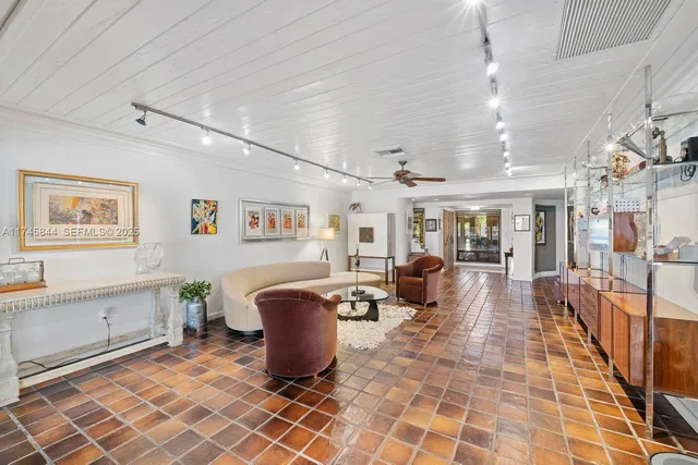 a living room with furniture a flat screen tv and next to a window