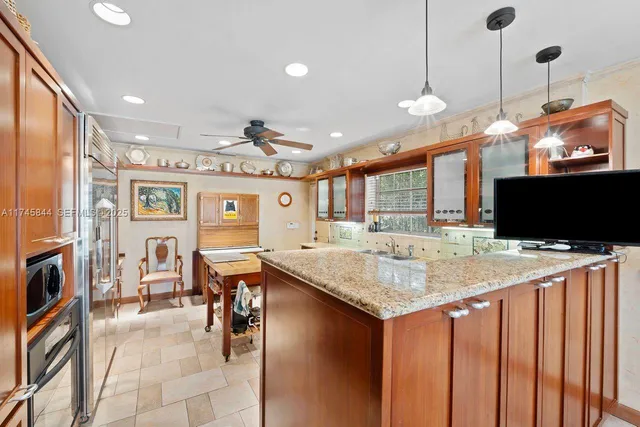 a kitchen with stainless steel appliances granite countertop a kitchen island a stove and a sink