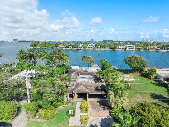 an aerial view of a house with a lake view and mountain view in back