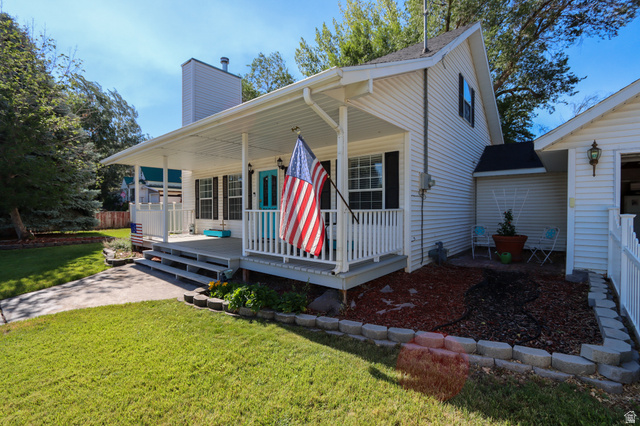 270 East 100 North Monroe, UT 84754 - Photo 4 of 65 White siding exterior with a covered porch featuring white railings, a contrasting blue entry door, and dark window shutters
