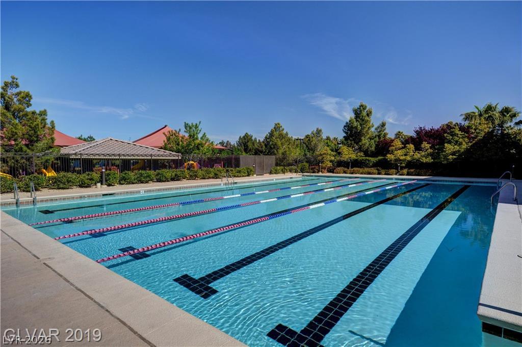 87 Tall Ruff Drive Las Vegas, NV 89148 - Photo 10 of 71 A pristine lap pool with a vibrant blue sky creates an inviting outdoor oasis.