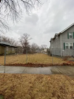 a view of a yard with wooden fence