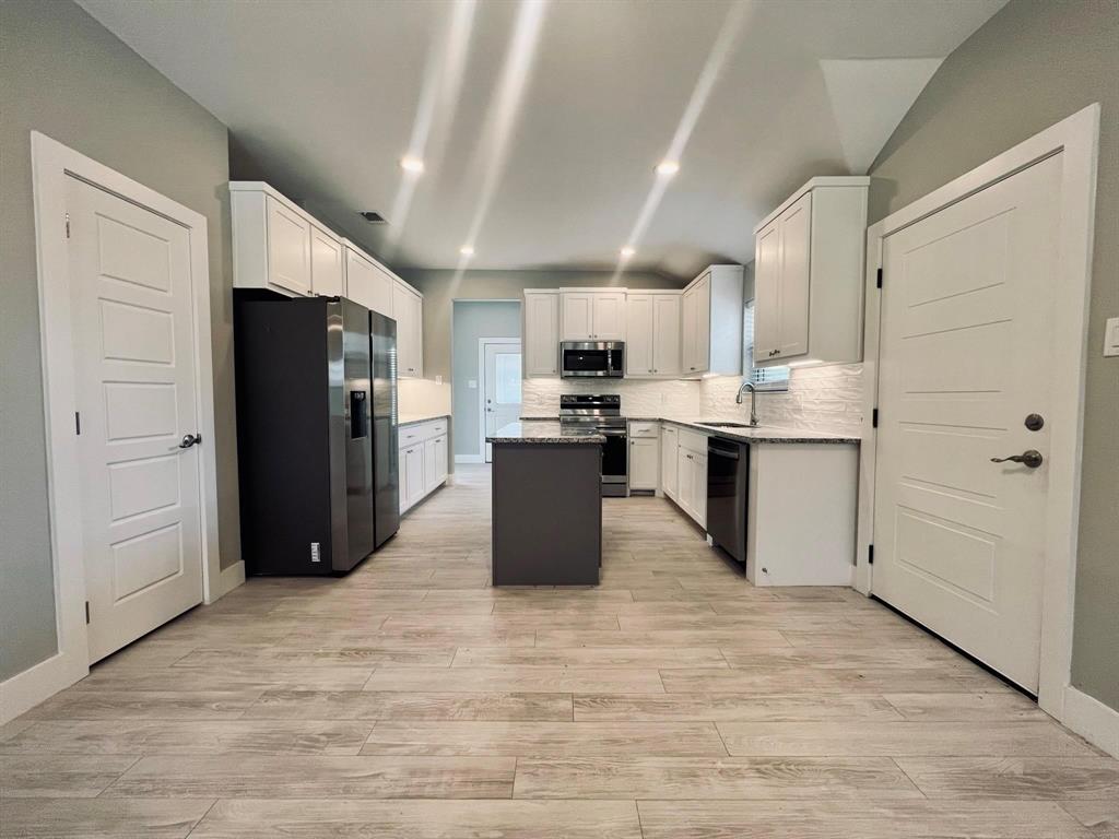 605 North Friendship Road Sherman, TX 75092 - Photo 11 of 17 a kitchen with stainless steel appliances kitchen island granite countertop a refrigerator and a stove top oven