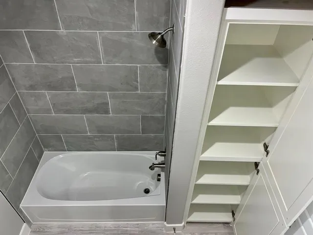 a view of a room with a ceiling fan and a hardwood floor