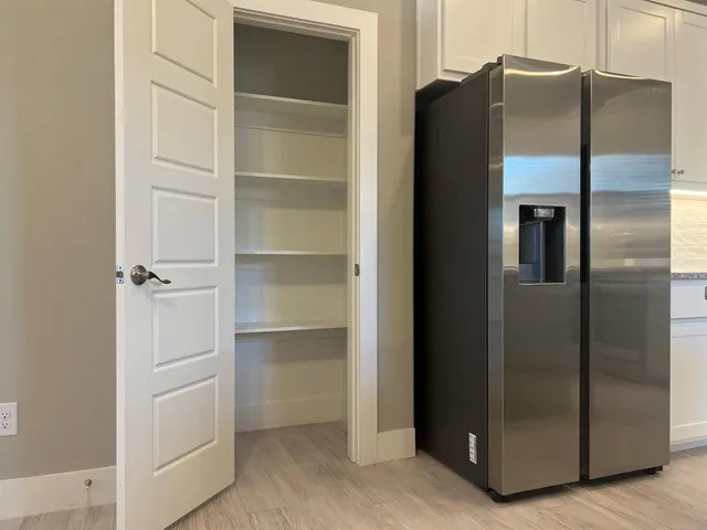 a kitchen with stainless steel appliances kitchen island granite countertop a refrigerator and a stove top oven