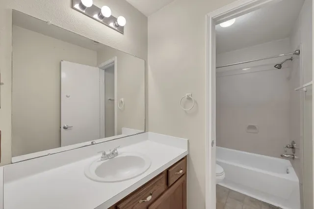 a bathroom with a sink double vanity granite tub and shower