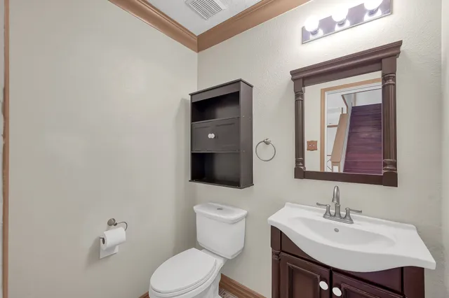 a bathroom with a toilet a sink and mirror