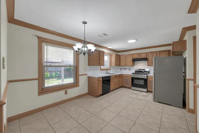 a kitchen with a refrigerator a sink dishwasher with a dining table and chairs