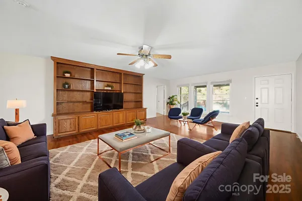 a living room with furniture a flat screen tv and a window