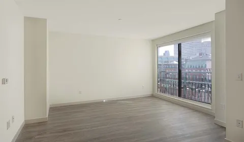 a view of an empty room with wooden floor