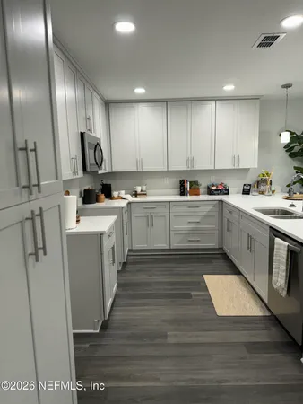 a kitchen with cabinets a sink and appliances