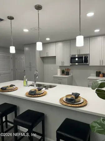 a kitchen with a sink a stove and chairs