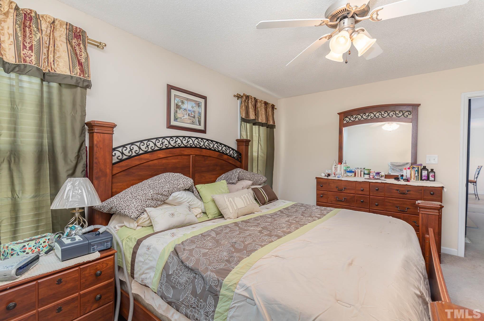 30 Rolling Cloud Drive Louisburg, NC 27549 - Photo 11 of 25 a bedroom with a bed and a mirror on the dresser