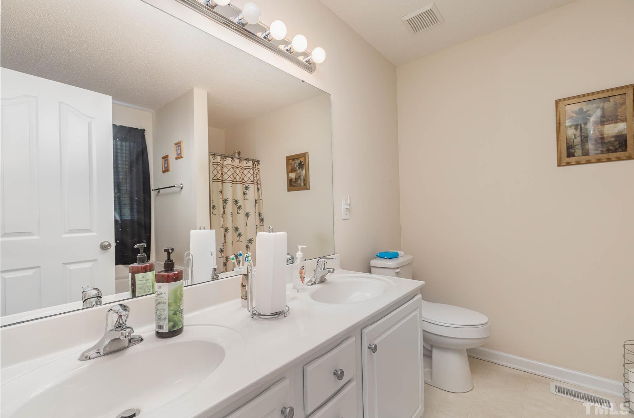 30 Rolling Cloud Drive Louisburg, NC 27549 - Photo 12 of 25 a bathroom with a granite countertop sink a toilet and a large mirror