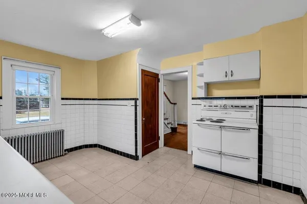 a kitchen with granite countertop white cabinets and sink
