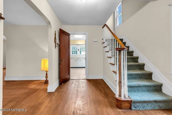 a view of an entryway with wooden floor and stairs