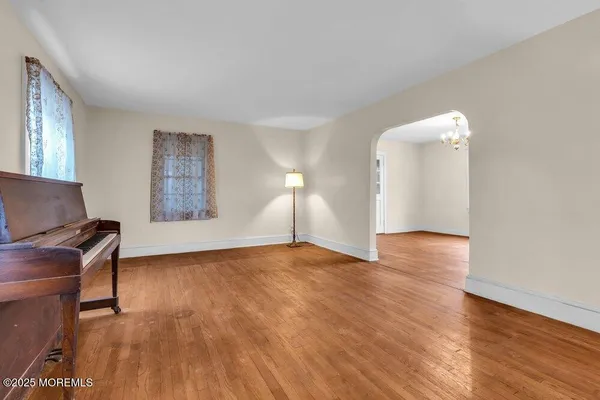a view of empty room with kitchen and window