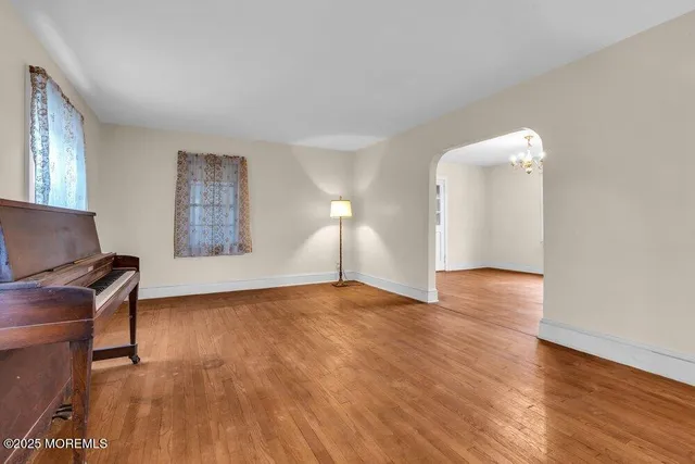 a view of empty room with kitchen and window