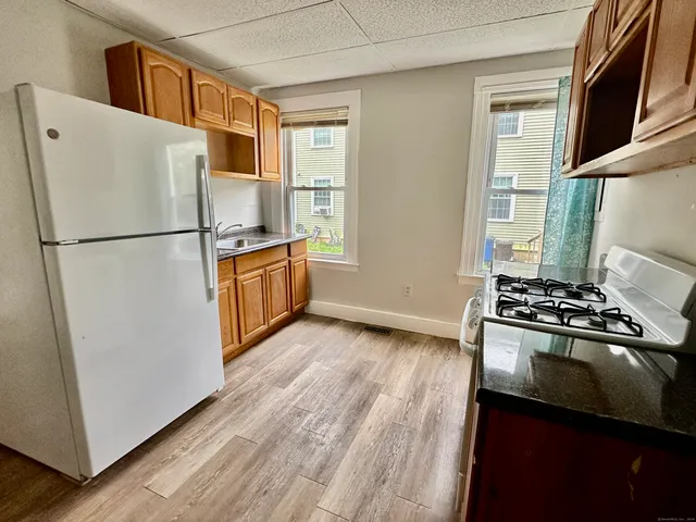 a white refrigerator freezer and a stove sitting inside of a kitchen