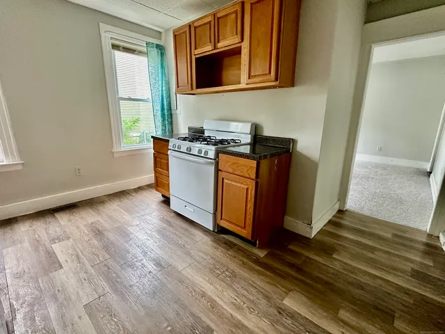 a view of a kitchen with wooden floor and a sink