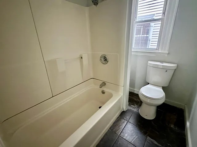 a bathroom with a toilet and a bathtub