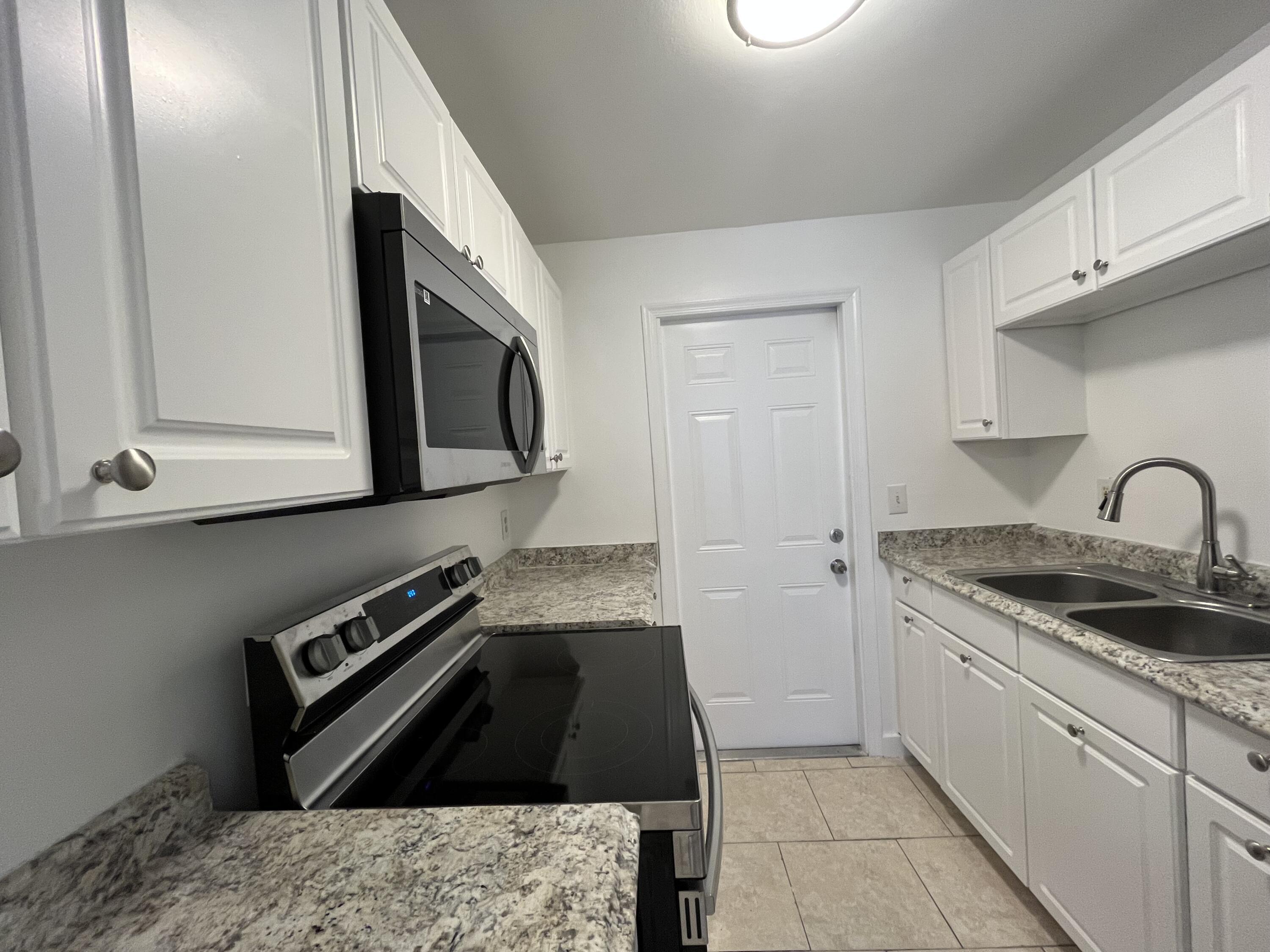 353 Silver Beach Road Riviera Beach, FL 33403 - Photo 6 of 10 a kitchen with granite countertop a stove and a sink