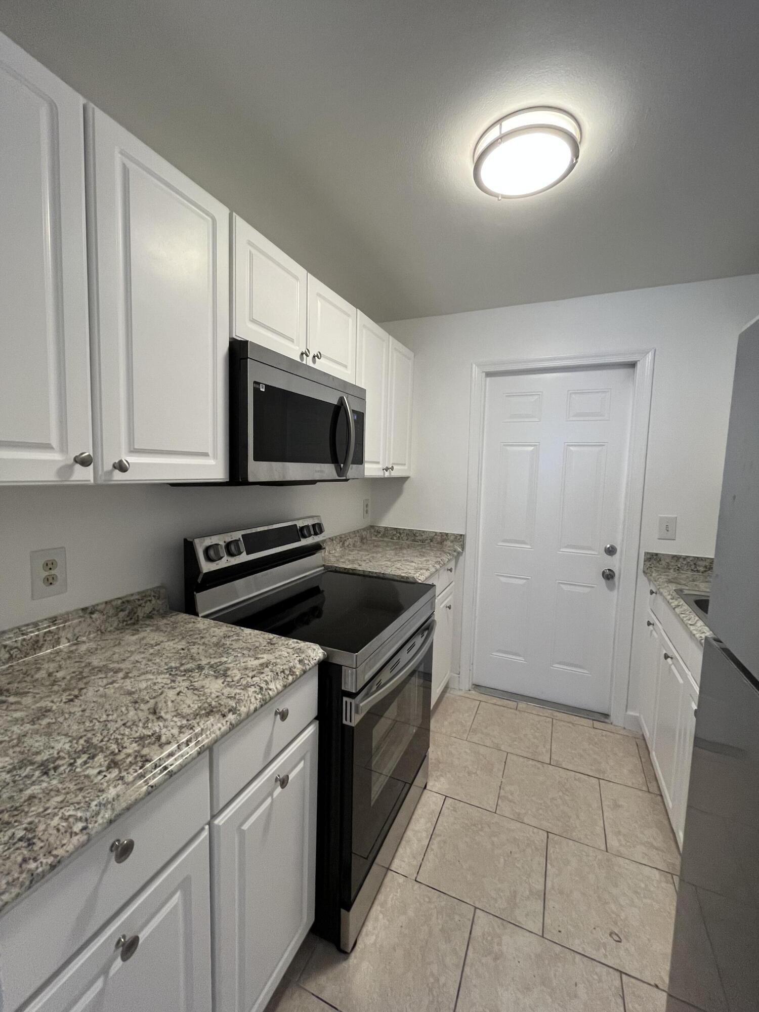 353 Silver Beach Road Riviera Beach, FL 33403 - Photo 7 of 10 a kitchen with a stove a sink and a microwave