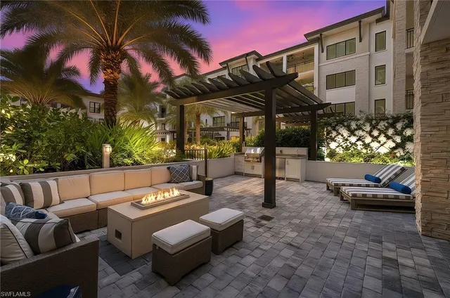 a view of a patio with a table and chairs under an umbrella with a couch